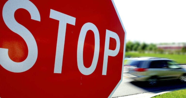 Car zooming through a stop sign